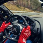 Vodič v pretekárskych rukaviciach drží volant športového vozidla Bugatti Chiron