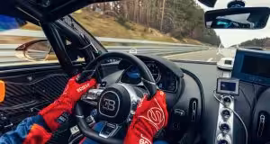 Vodič v pretekárskych rukaviciach drží volant športového vozidla Bugatti Chiron