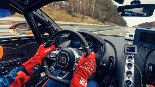 bugatti-chiron-9 Vodič v pretekárskych rukaviciach drží volant športového vozidla Bugatti Chiron