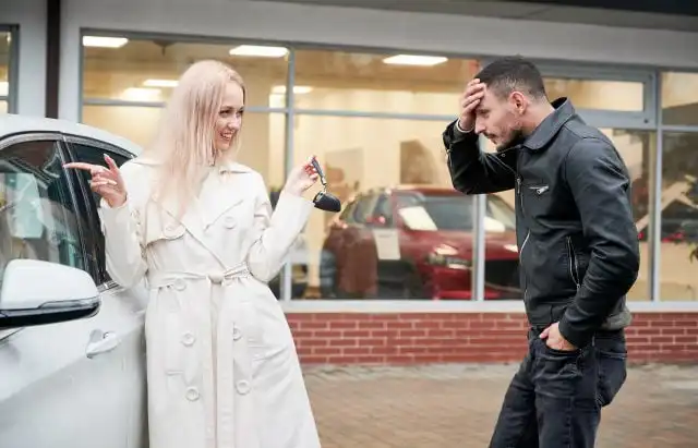 Girl showing guy keys to newly purchased automobile.